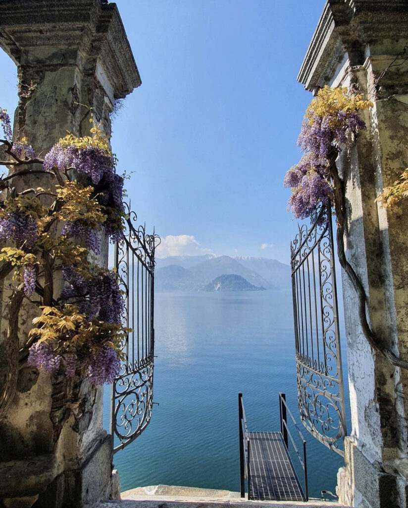 Heiratsantrag am Comer See: So wird der wichtigste Moment deines Lebens unvergesslich 6 Schmiedeeiserne Tore geben den Blick frei auf den Comer See mit seinen violetten Glyzinien und den fernen Bergen - eine Traumkulisse in Italien, perfekt für jeden Hochzeitsplaner.